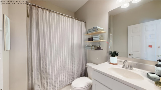 bathroom featuring vanity, toilet, and a shower with shower curtain