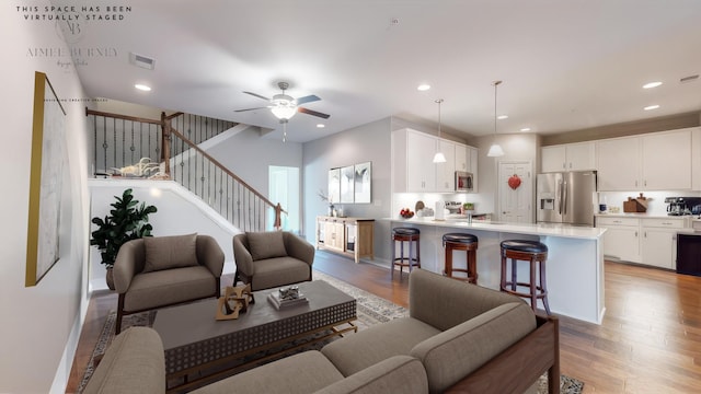 living room featuring ceiling fan and light wood-type flooring