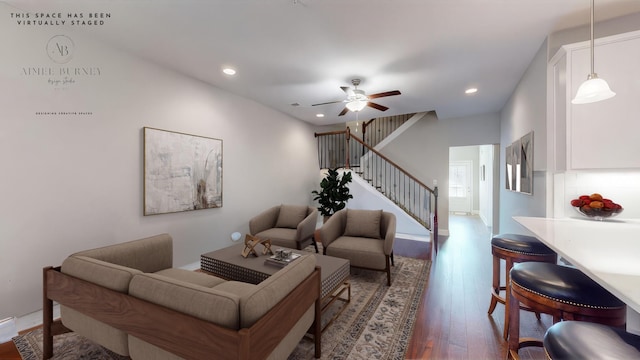 living room featuring dark wood-type flooring and ceiling fan