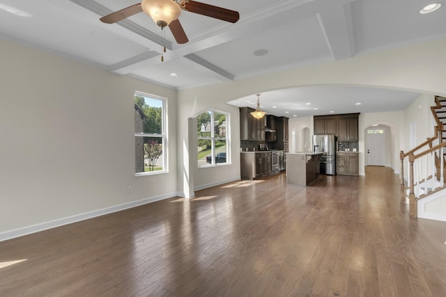 unfurnished living room with ceiling fan, crown molding, beamed ceiling, and dark wood-type flooring