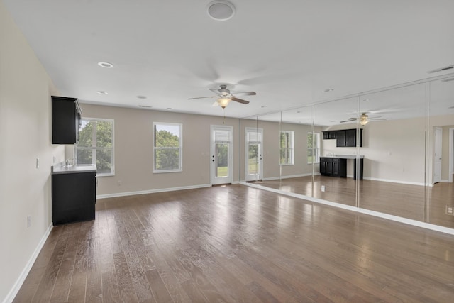 unfurnished living room with ceiling fan and dark hardwood / wood-style flooring