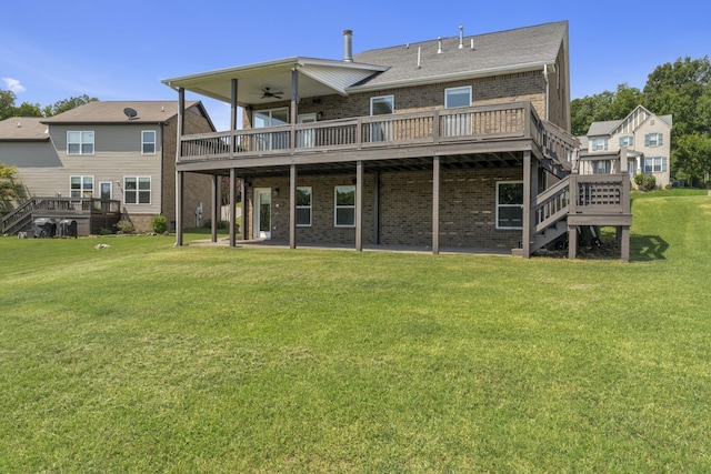 back of property with a deck, ceiling fan, and a lawn