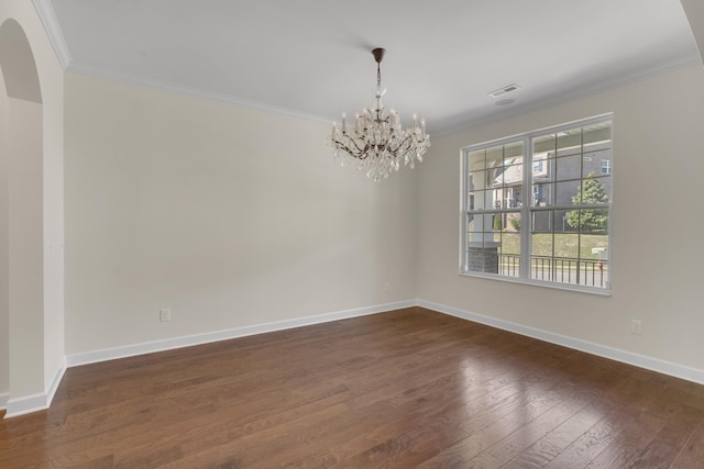 empty room with a chandelier, dark hardwood / wood-style floors, and ornamental molding