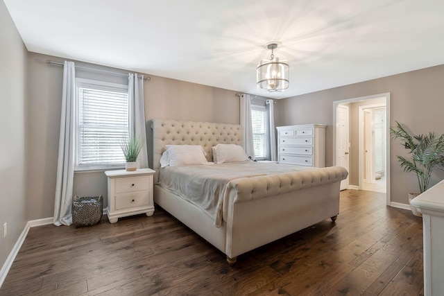 bedroom with dark wood-type flooring and a notable chandelier