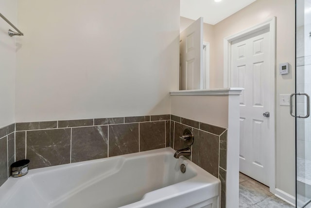 bathroom with a tub to relax in and tile patterned floors