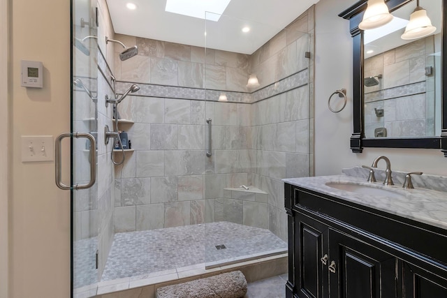 bathroom with tile patterned flooring, vanity, a shower with shower door, and a skylight