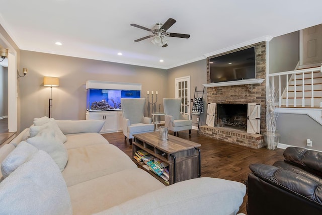 living room with a fireplace, dark hardwood / wood-style floors, ceiling fan, and ornamental molding