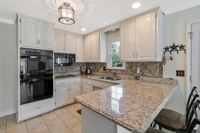 kitchen featuring black appliances, white cabinets, kitchen peninsula, and sink