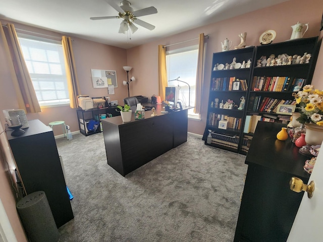 office space featuring a wealth of natural light, ceiling fan, and light colored carpet