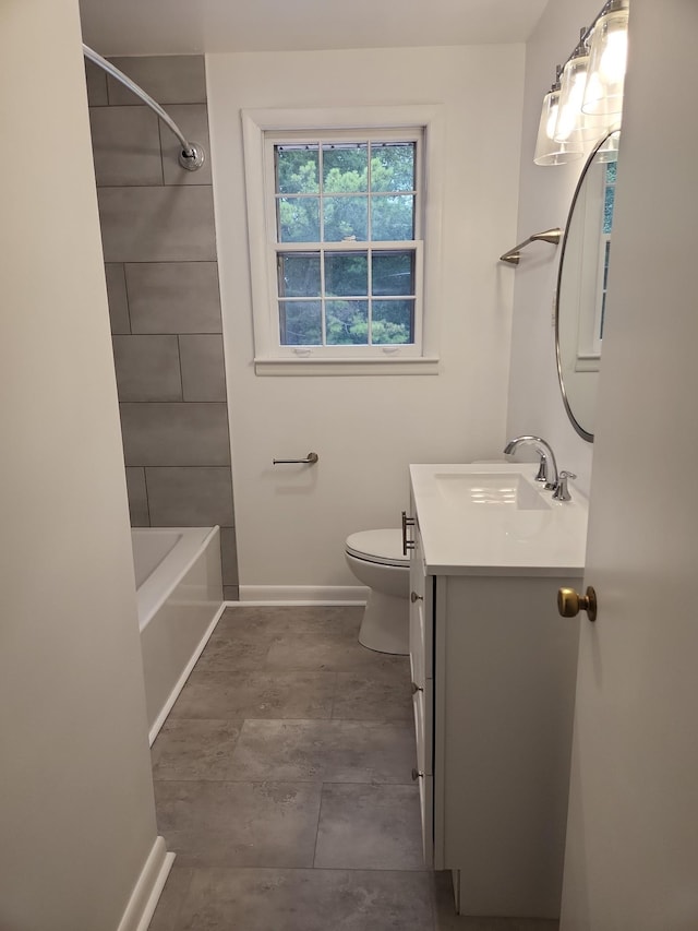 full bathroom featuring tiled shower / bath, vanity, and toilet