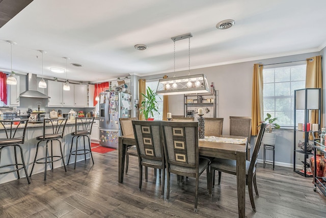 dining area featuring dark hardwood / wood-style floors and crown molding