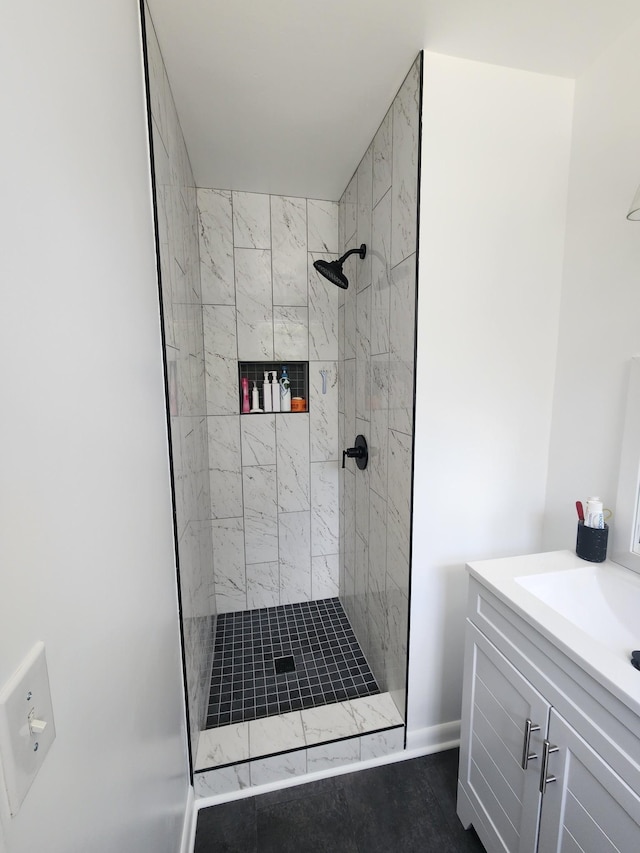 bathroom featuring tiled shower and vanity