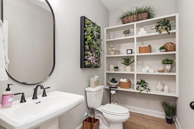 bathroom with hardwood / wood-style floors, toilet, and sink