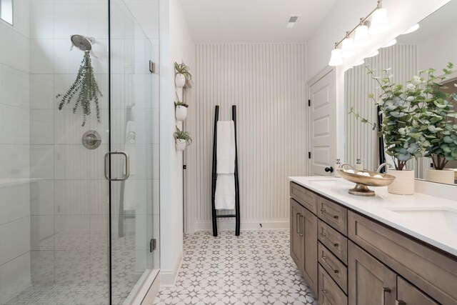 bathroom with vanity and a shower with door