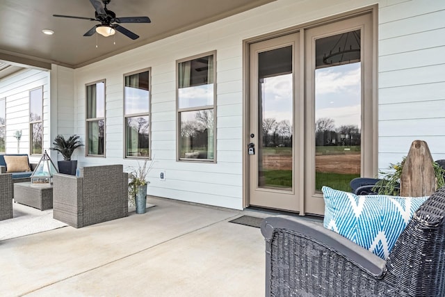 entrance to property with a patio area, ceiling fan, and an outdoor living space