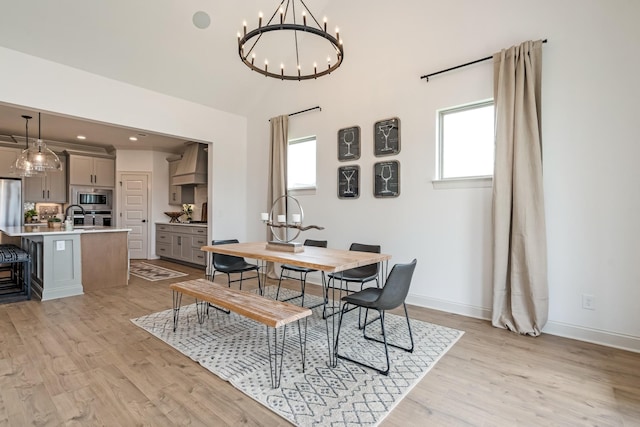 dining room with light hardwood / wood-style flooring and a notable chandelier