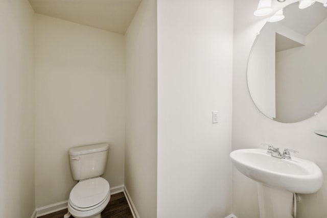 bathroom featuring hardwood / wood-style flooring, toilet, and sink