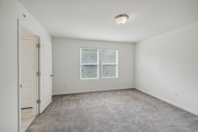 unfurnished room featuring light carpet