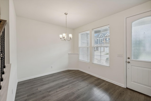 unfurnished dining area featuring dark hardwood / wood-style floors and a notable chandelier