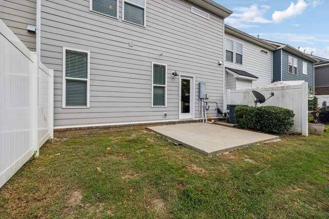 back of property with a yard and a patio