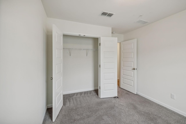 unfurnished bedroom with light carpet and a closet