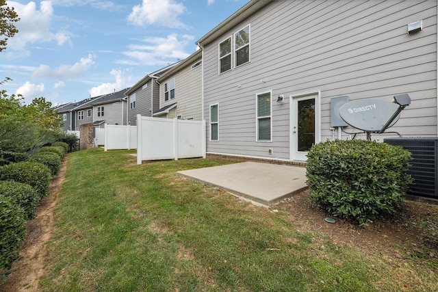 back of property featuring a lawn, central AC unit, and a patio