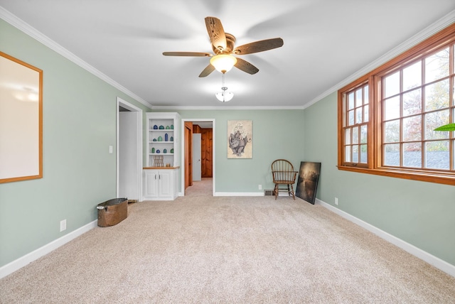 unfurnished room with ceiling fan, light colored carpet, and ornamental molding