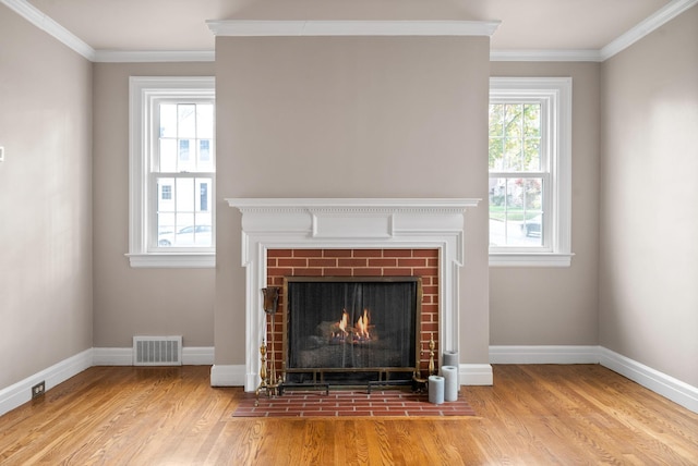 details featuring crown molding, hardwood / wood-style floors, and a brick fireplace