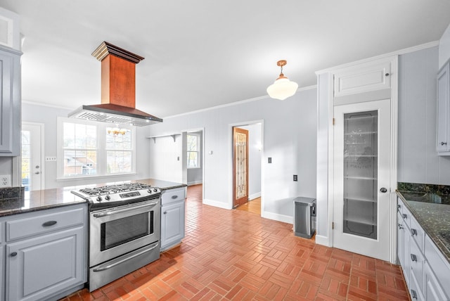 kitchen featuring ornamental molding, gas range, extractor fan, dark stone countertops, and hanging light fixtures