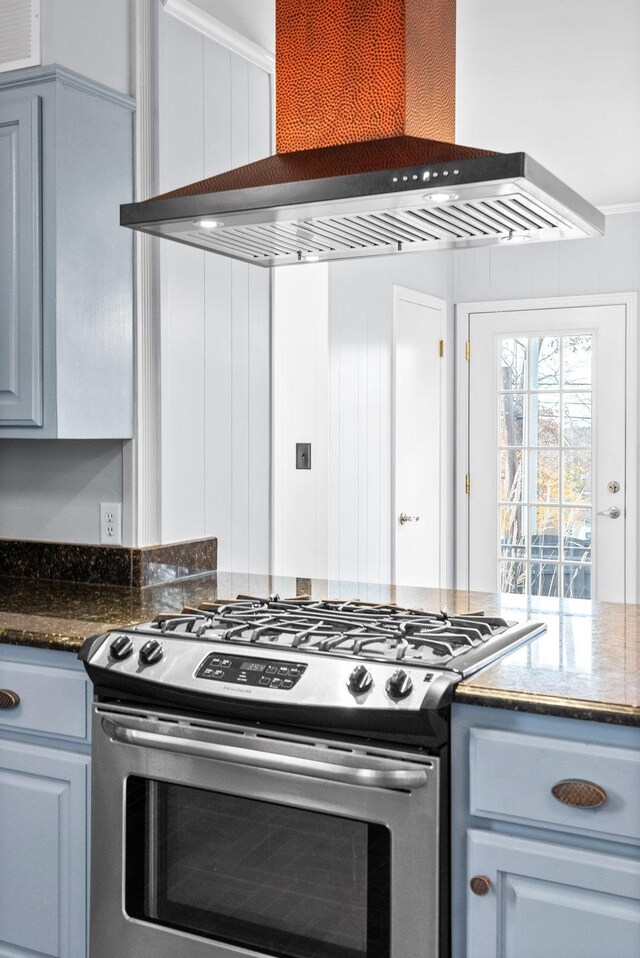 kitchen with stainless steel range oven, wall chimney range hood, and ornamental molding