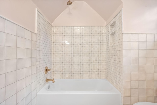 bathroom with lofted ceiling and tile walls