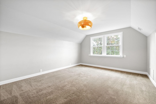 additional living space with carpet floors and vaulted ceiling