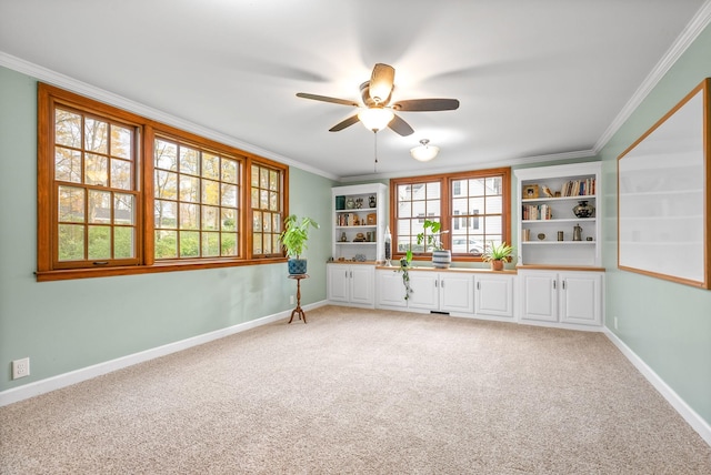 spare room featuring crown molding, carpet, and ceiling fan