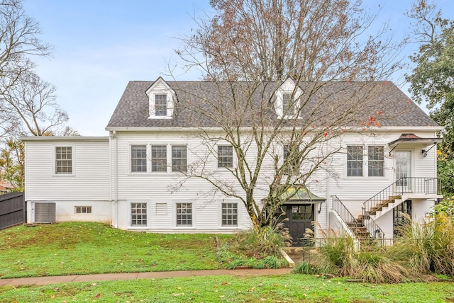 view of front of home with a front lawn and cooling unit