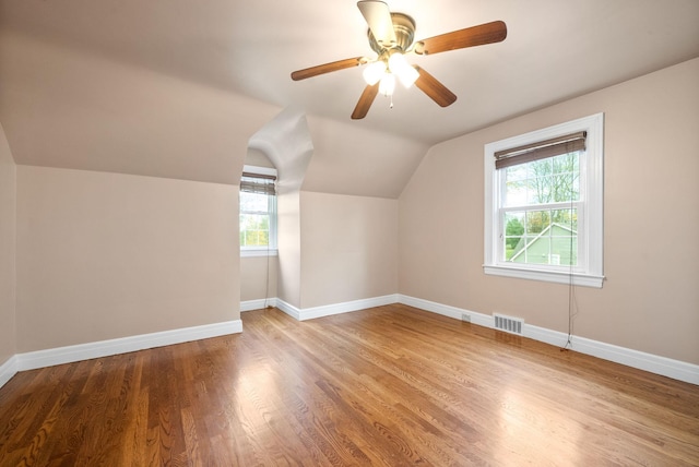 additional living space featuring plenty of natural light, ceiling fan, lofted ceiling, and light hardwood / wood-style flooring