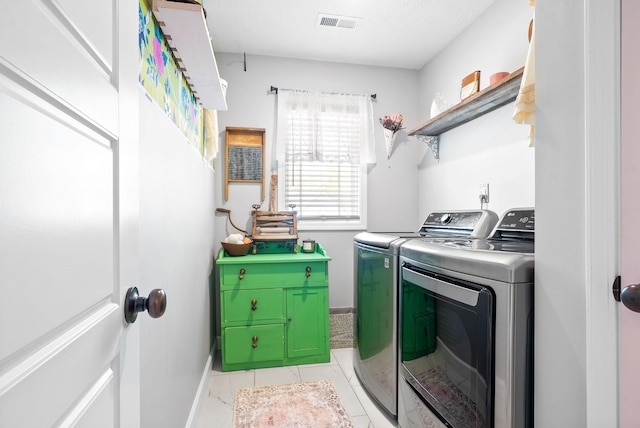 clothes washing area featuring separate washer and dryer and light tile patterned floors