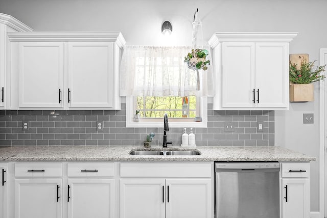 kitchen featuring backsplash, white cabinetry, stainless steel dishwasher, and sink