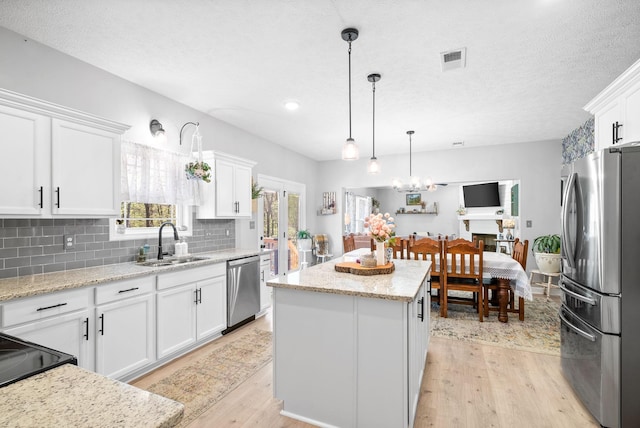 kitchen featuring a center island, white cabinetry, sink, and appliances with stainless steel finishes