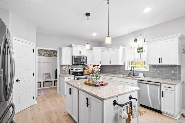 kitchen featuring a center island, white cabinetry, sink, and appliances with stainless steel finishes