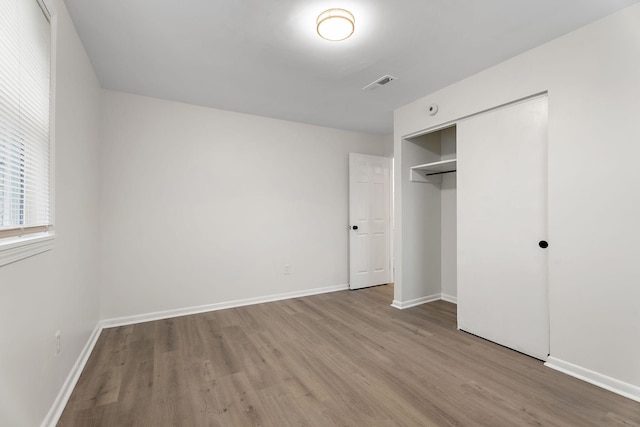 unfurnished bedroom with a closet and light hardwood / wood-style flooring