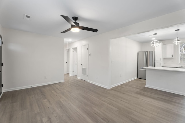 unfurnished living room featuring ceiling fan and light wood-type flooring