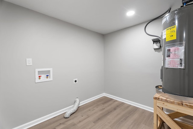 clothes washing area featuring hookup for an electric dryer, washer hookup, electric water heater, and hardwood / wood-style flooring