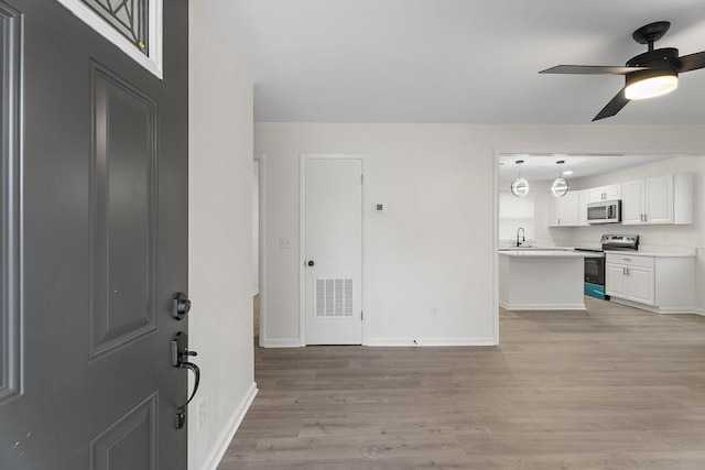 foyer entrance with ceiling fan, light hardwood / wood-style flooring, and sink