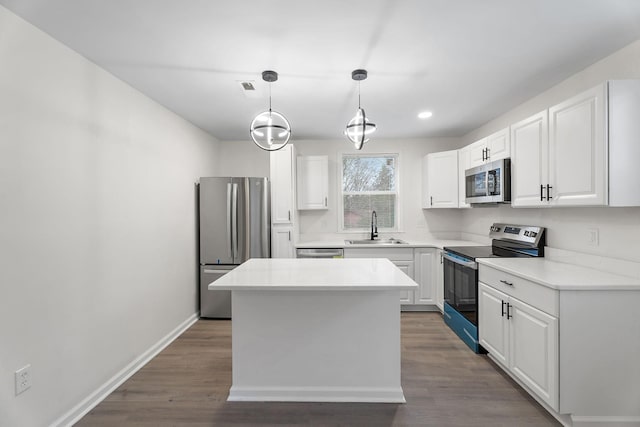 kitchen featuring white cabinets, stainless steel appliances, hanging light fixtures, and sink