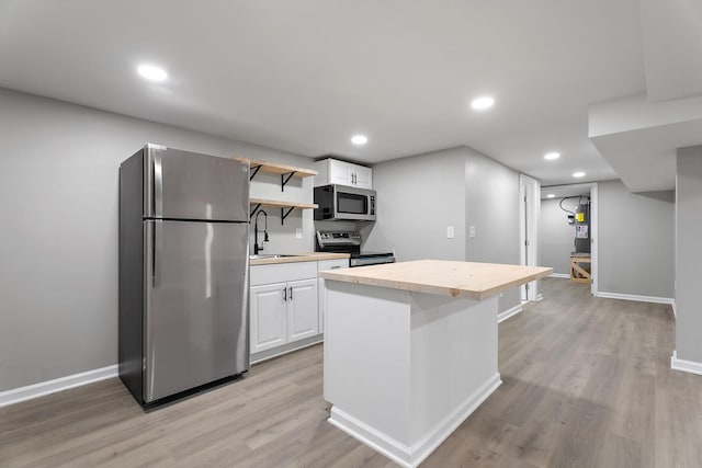 kitchen with white cabinetry, sink, light hardwood / wood-style floors, and appliances with stainless steel finishes