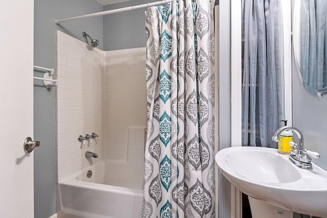 bathroom with shower / bath combo with shower curtain and a sink