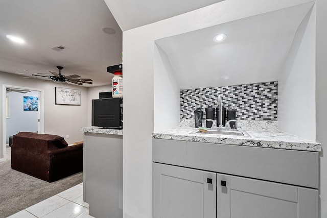 bar with ceiling fan, a sink, visible vents, marble finish floor, and tasteful backsplash