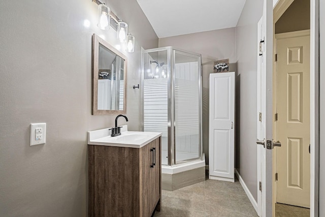 full bathroom with a shower stall, baseboards, tile patterned flooring, and vanity