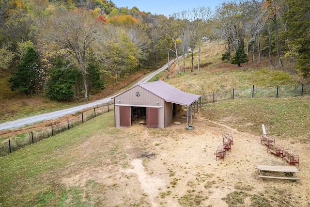 view of pole building with a forest view and fence