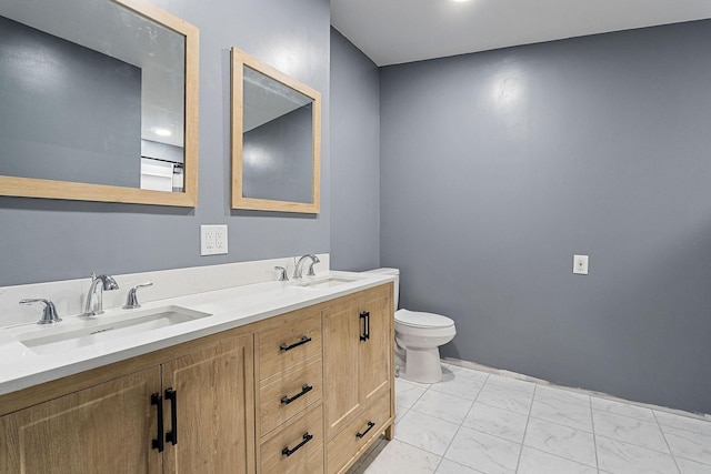 bathroom with marble finish floor, a sink, toilet, and double vanity